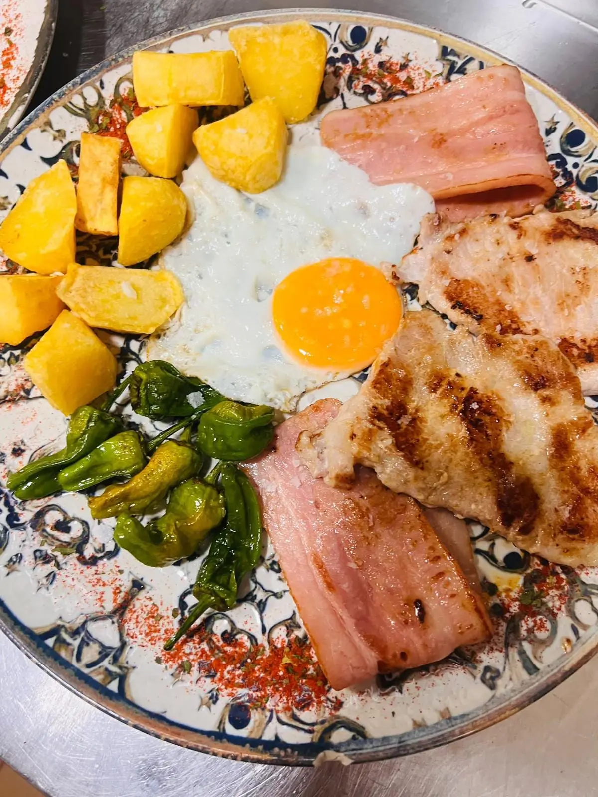 Plato combinado: lomo y jamón york a la plancha, huevo frito, patatas y pimientos de Padrón.