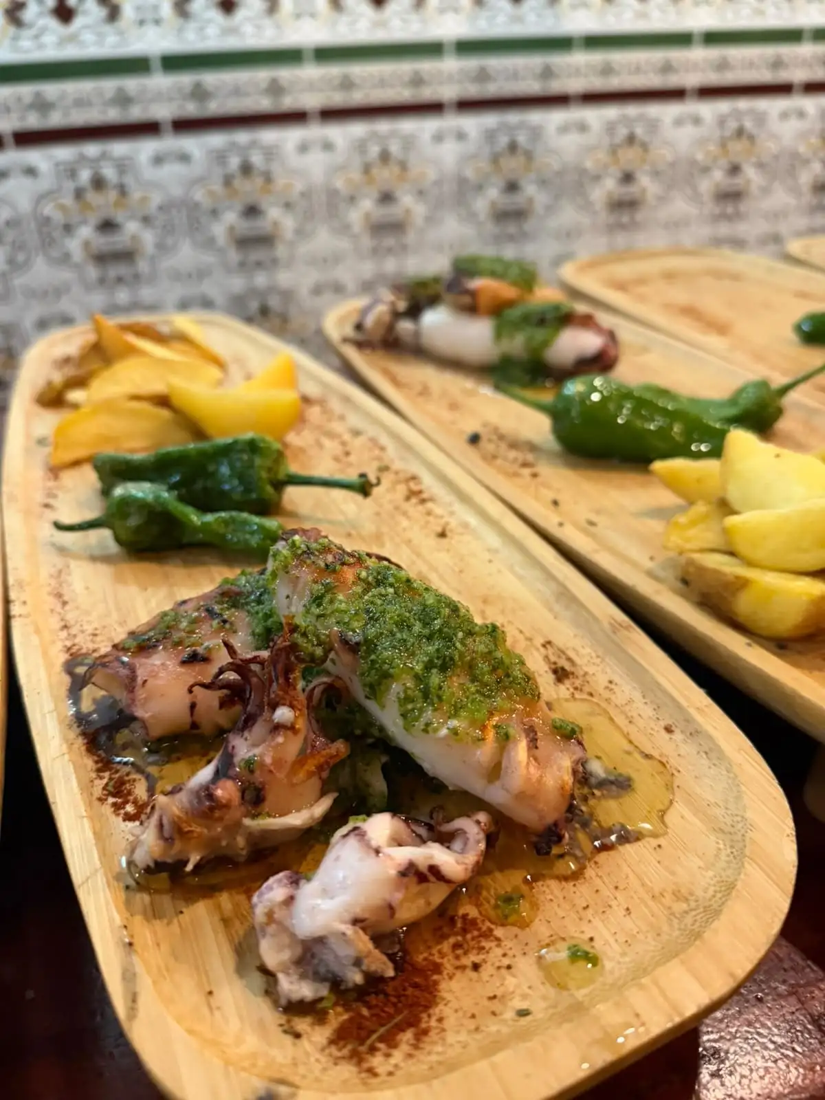 Sepia a la plancha con salsa verde de ajo y perejil, con pimientos de Padrón y patatas al lado.