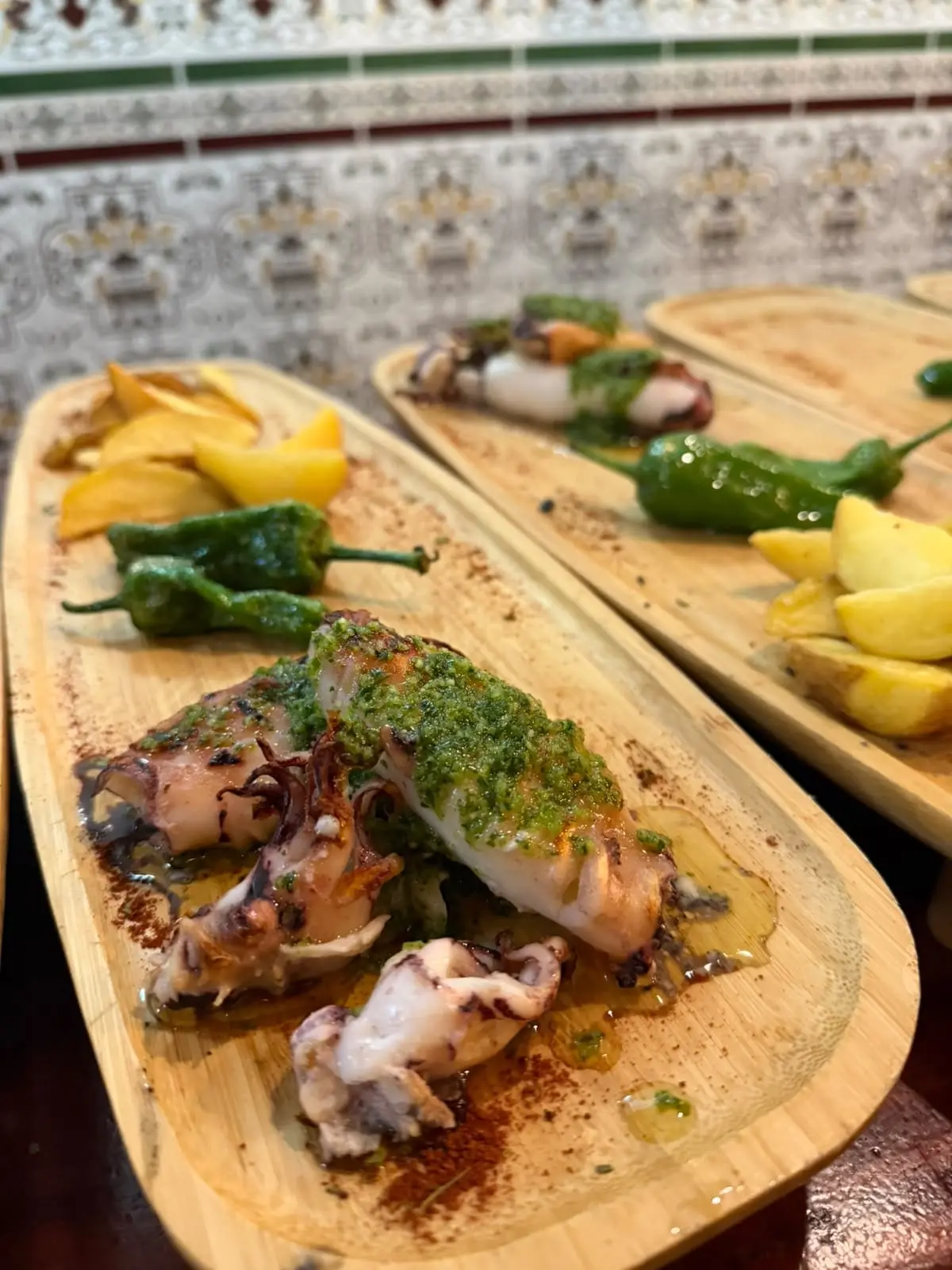 Sepia a la plancha con salsa verde de ajo y perejil, con pimientos de Padrón y patatas al lado.